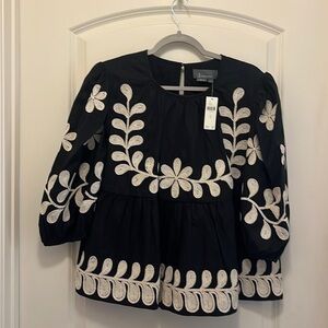 Beautiful Anthropologie black top with off white stitching. Never worn with tag.